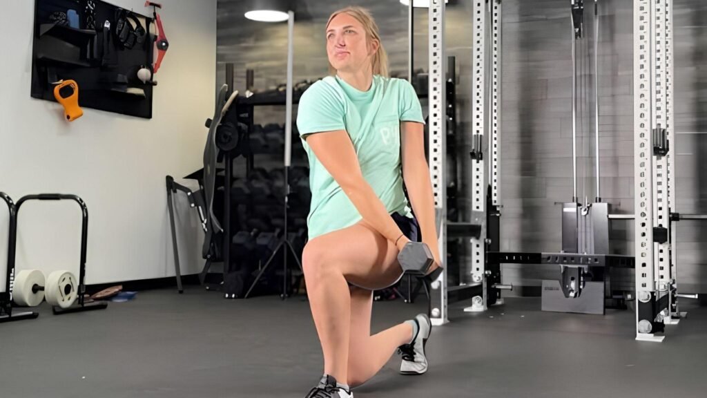 "Woman performing half kneeling dumbbell wood chop exercise for oblique workout"