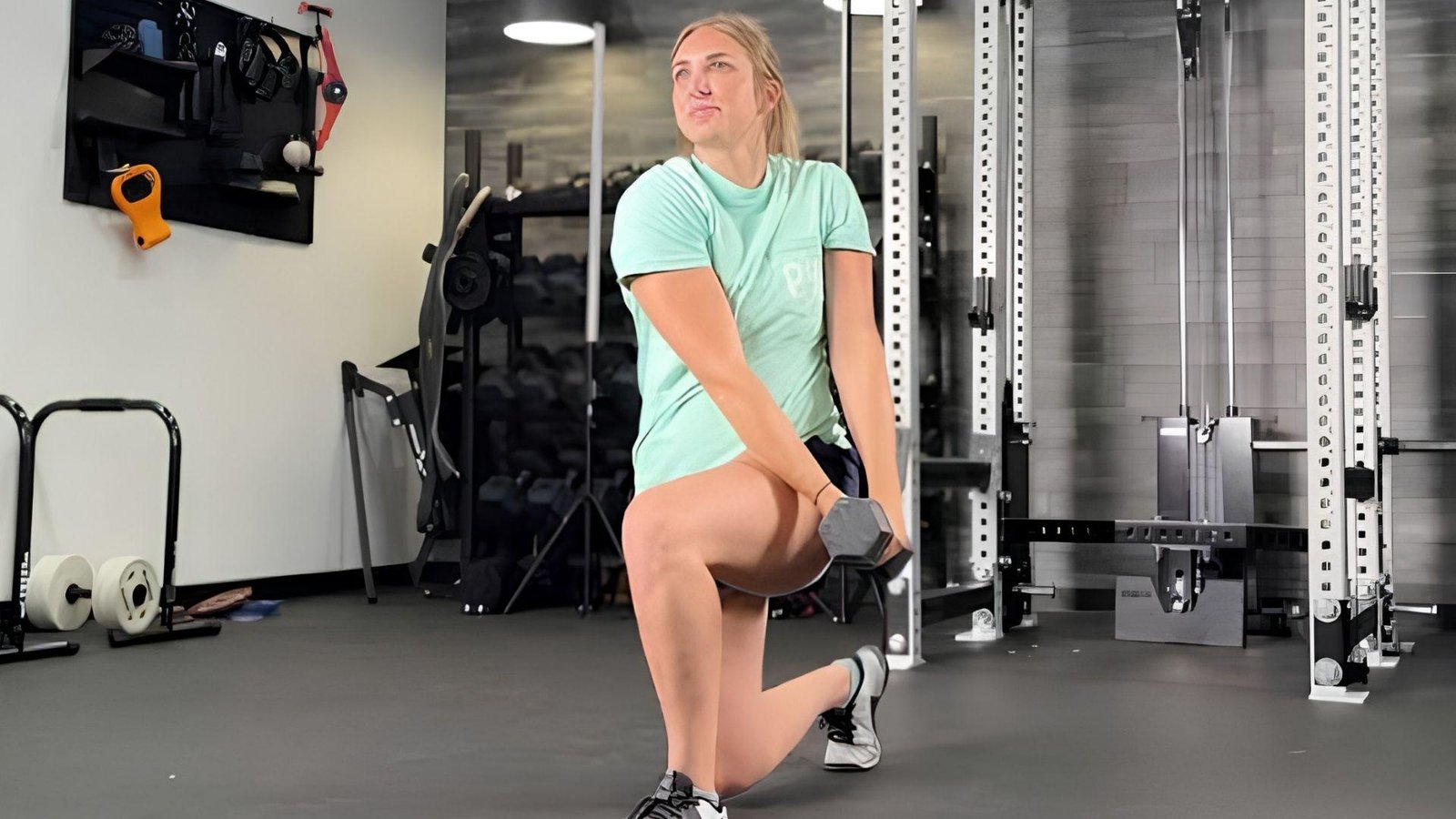 "Woman performing half kneeling dumbbell wood chop exercise for oblique workout"