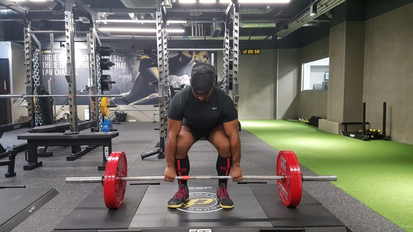man performing a conventional deadlift with proper hip hinge technique.