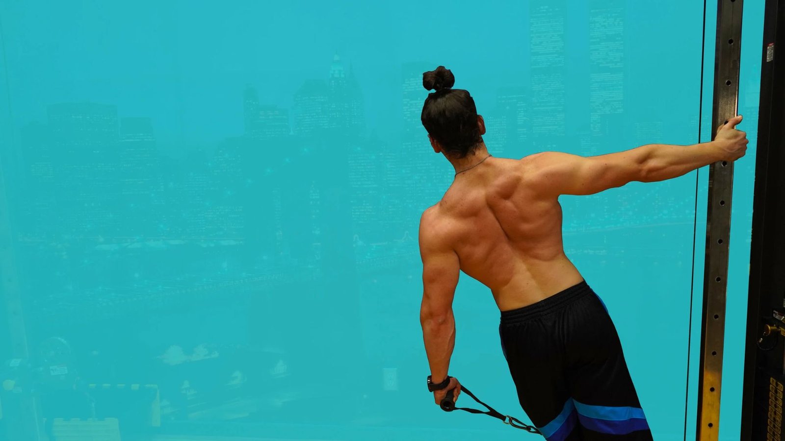 man performing a leaning cable lateral raise for better medial delt activation.