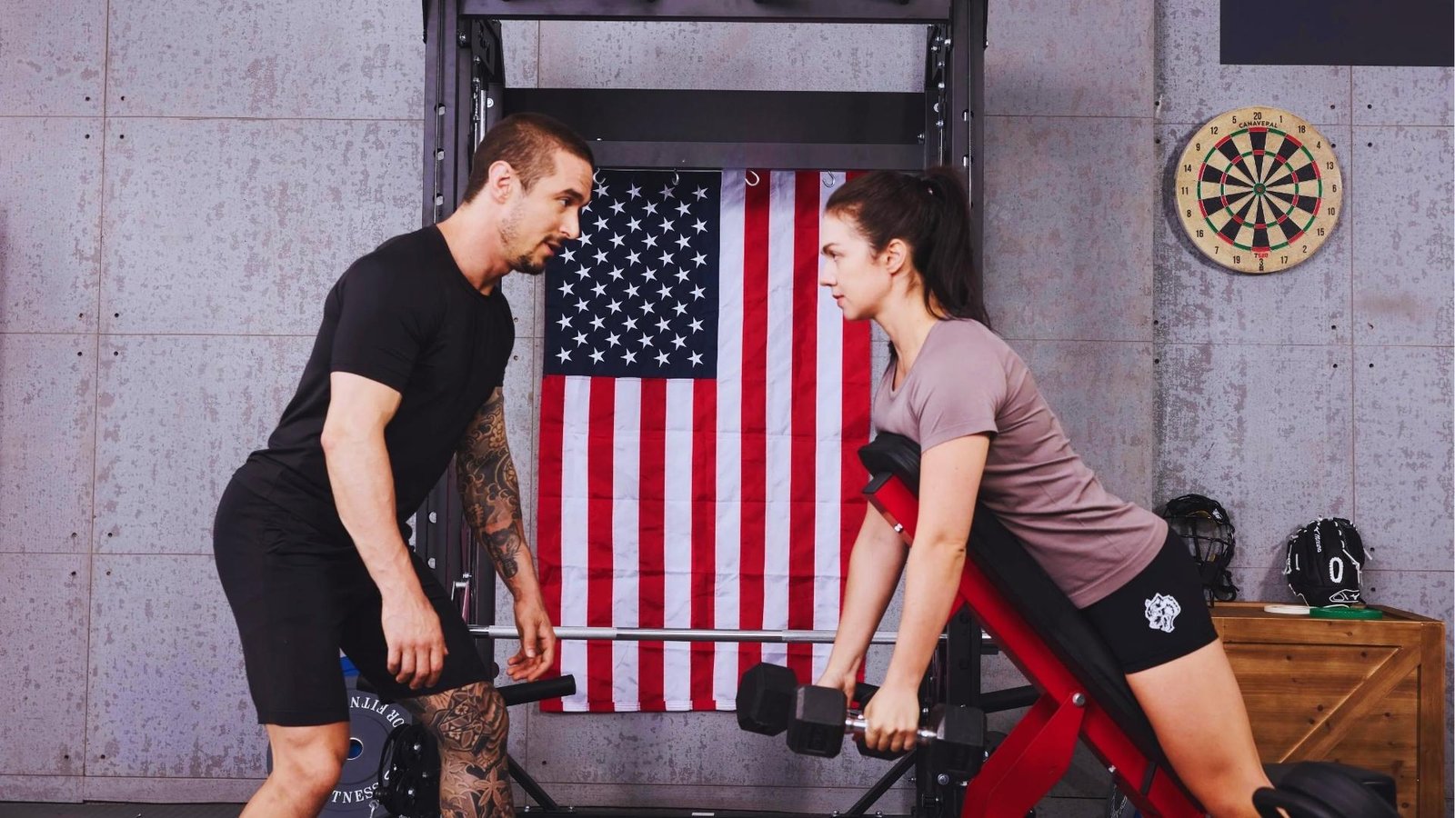 Woman doing incline bench dumbbell chest supported row with trainer coaching, back workout.