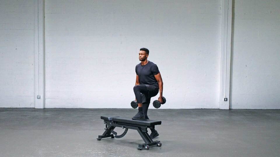 Man stepping onto a workout bench holding dumbbells.
