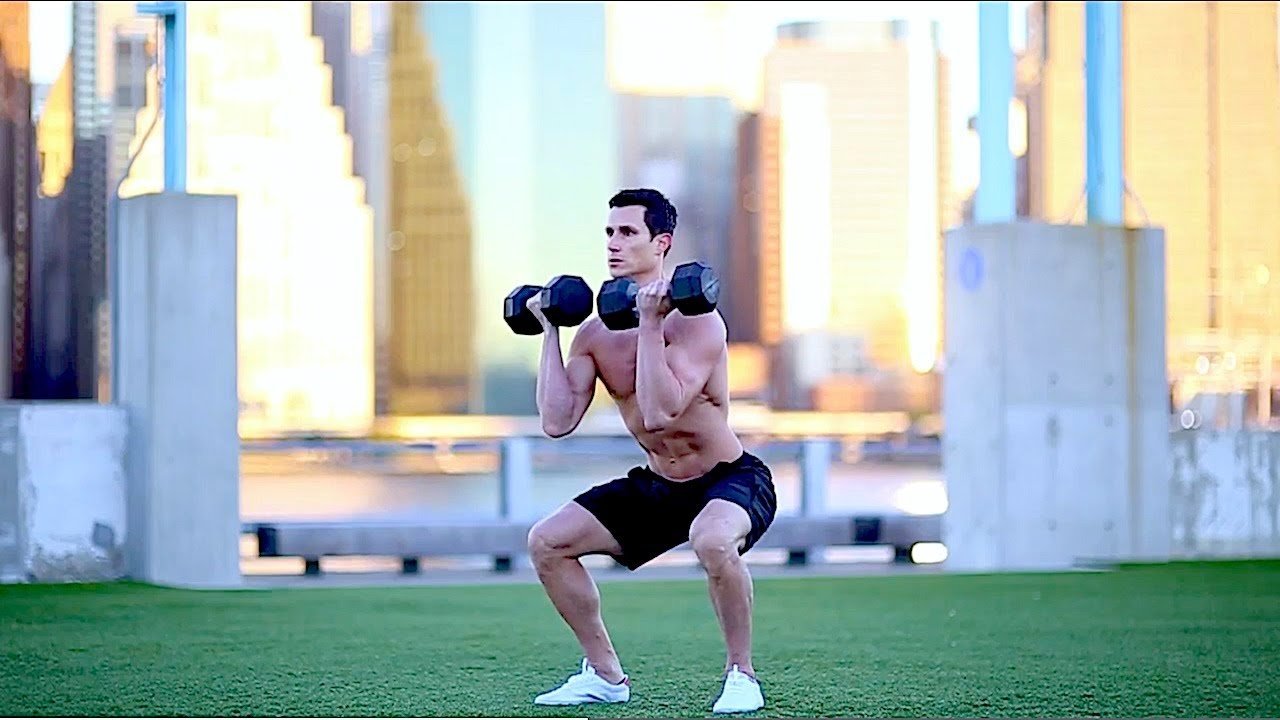 Person performing a dumbbell front squat.