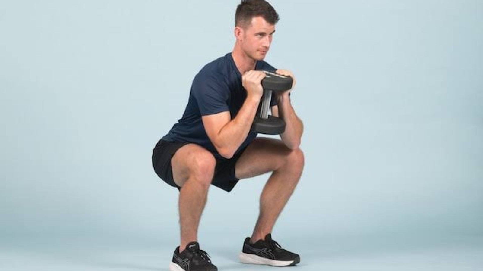 man doing a goblet squat with a dumbbell to build quad strength and improve knee stability.