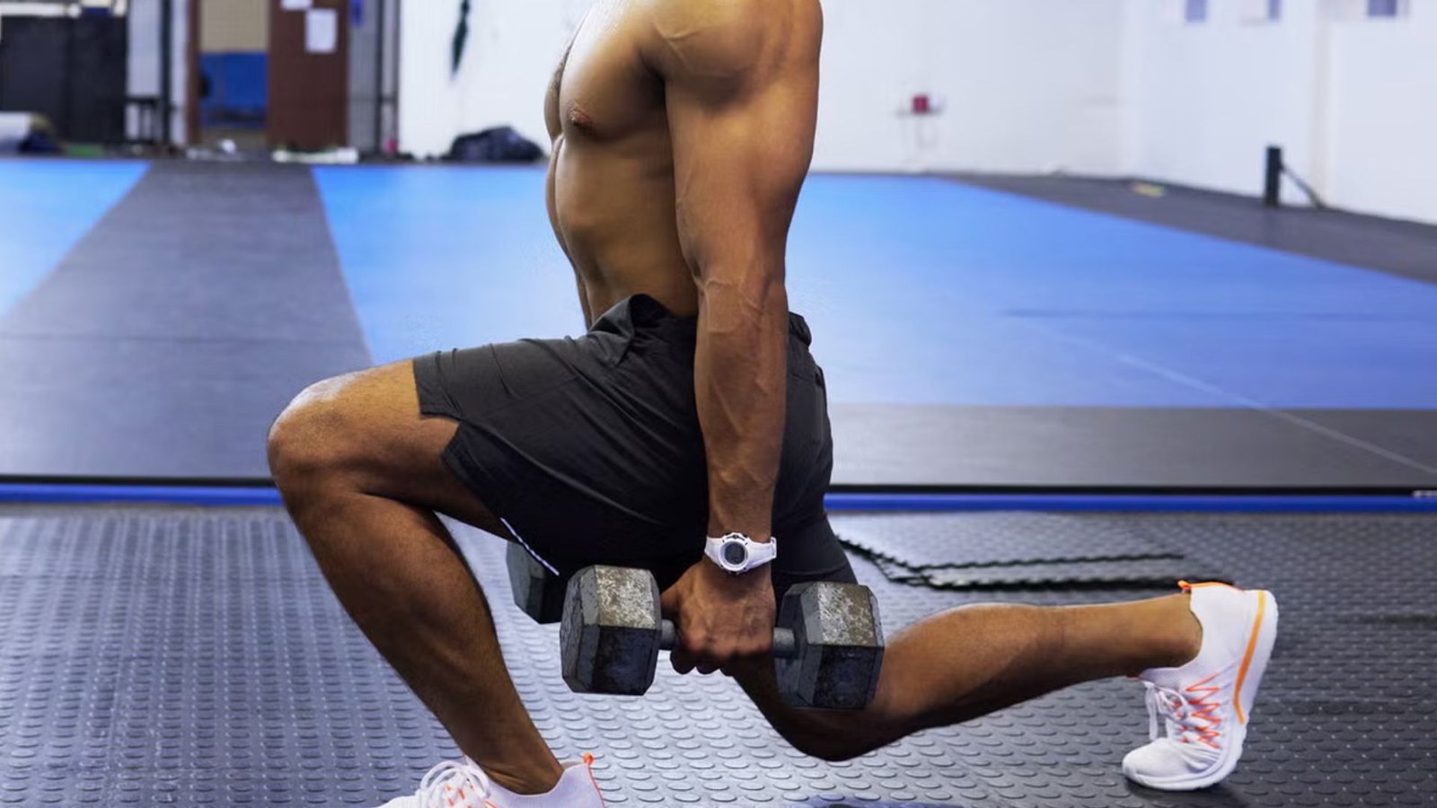 man performing walking lunges with dumbbells to build strong quads and balance.