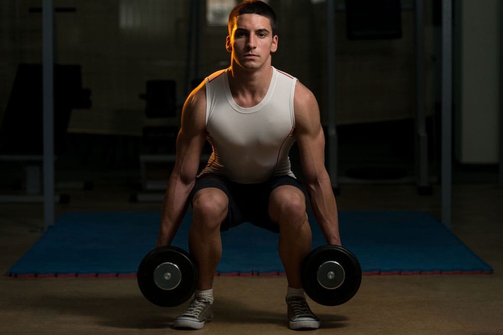 Dumbbell hack squat targeting the quadriceps.
