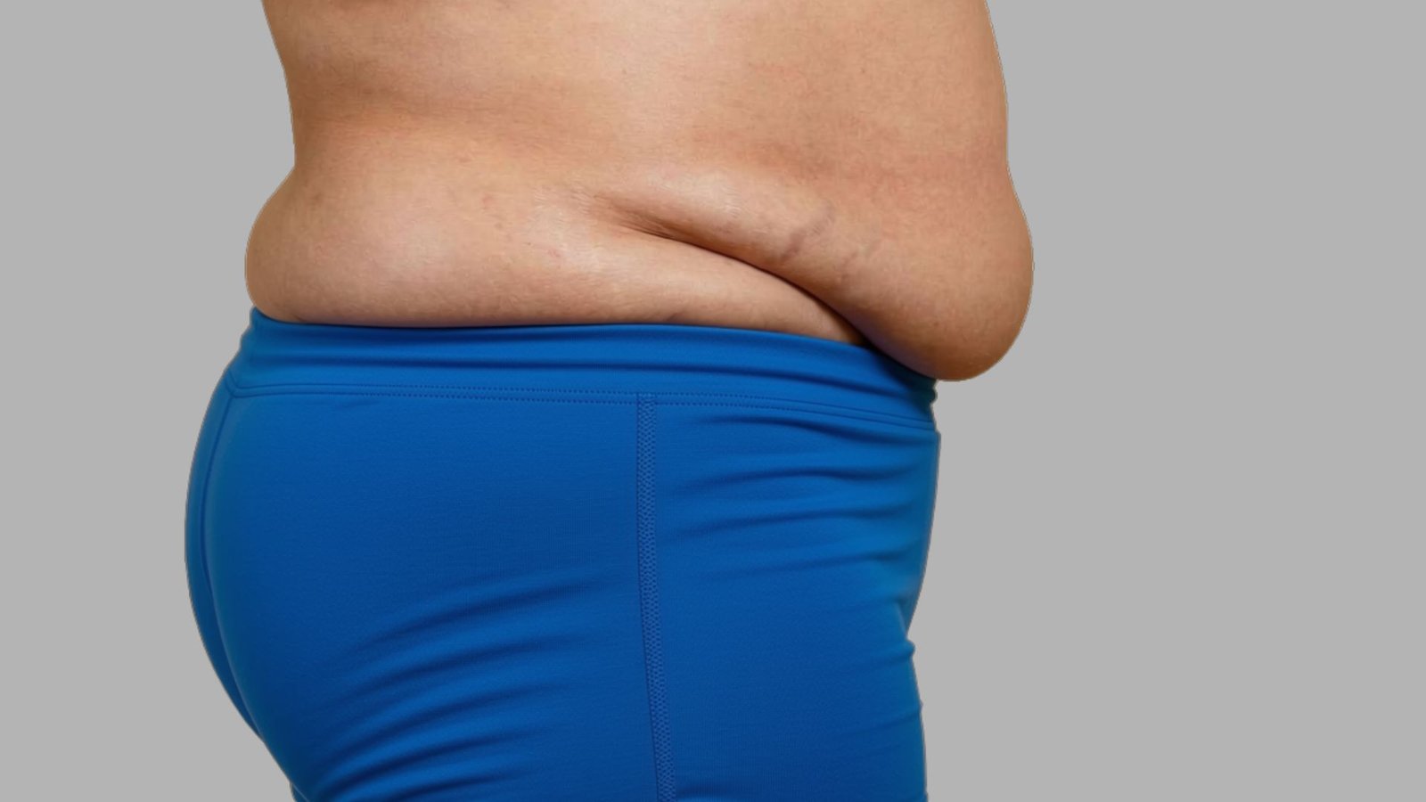 Woman holding lower abdomen to illustrate exercises to get rid of apron belly and improve core strength at home.