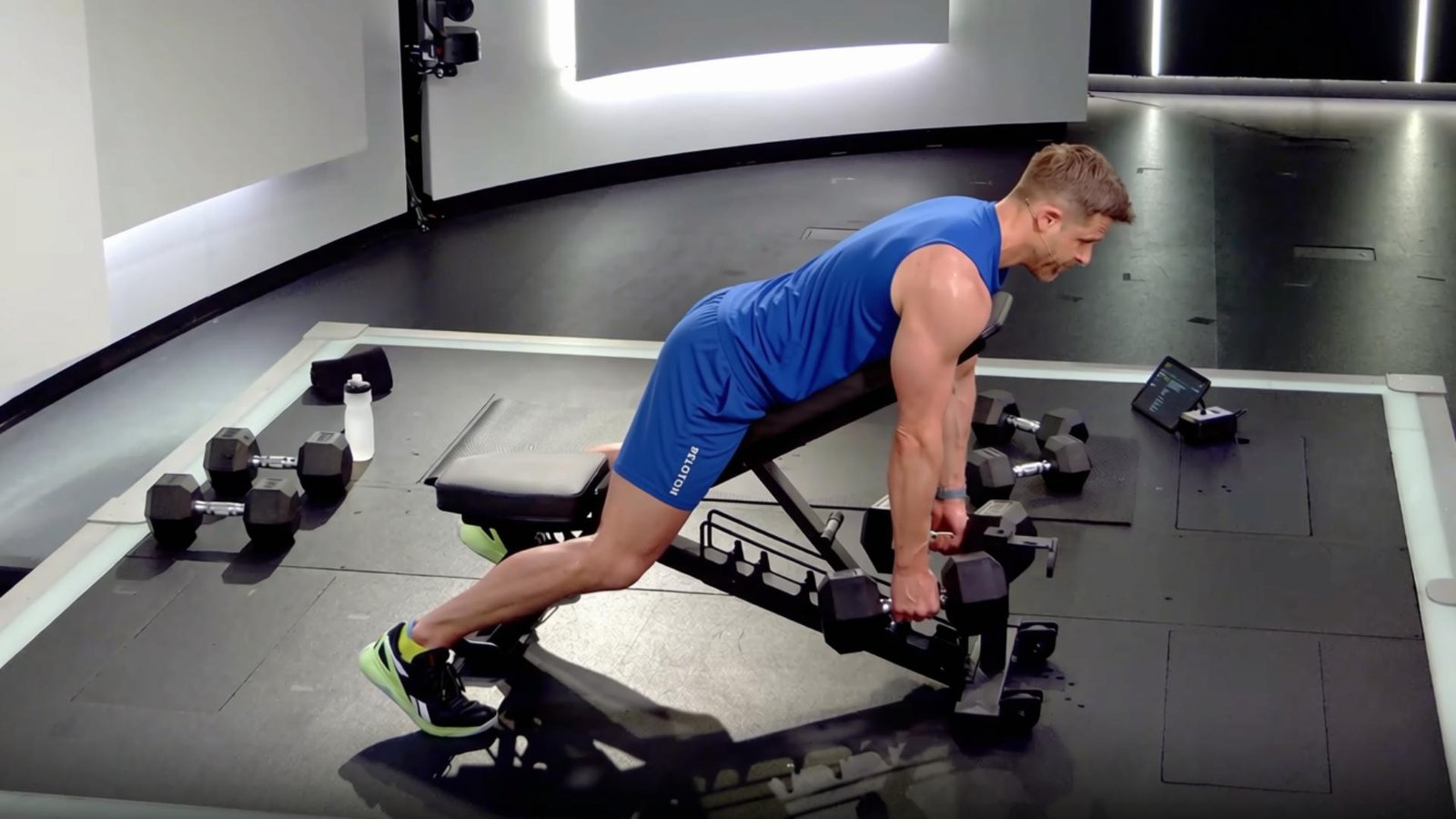Athlete performing a chest-supported dumbbell row on an incline bench with controlled movement.