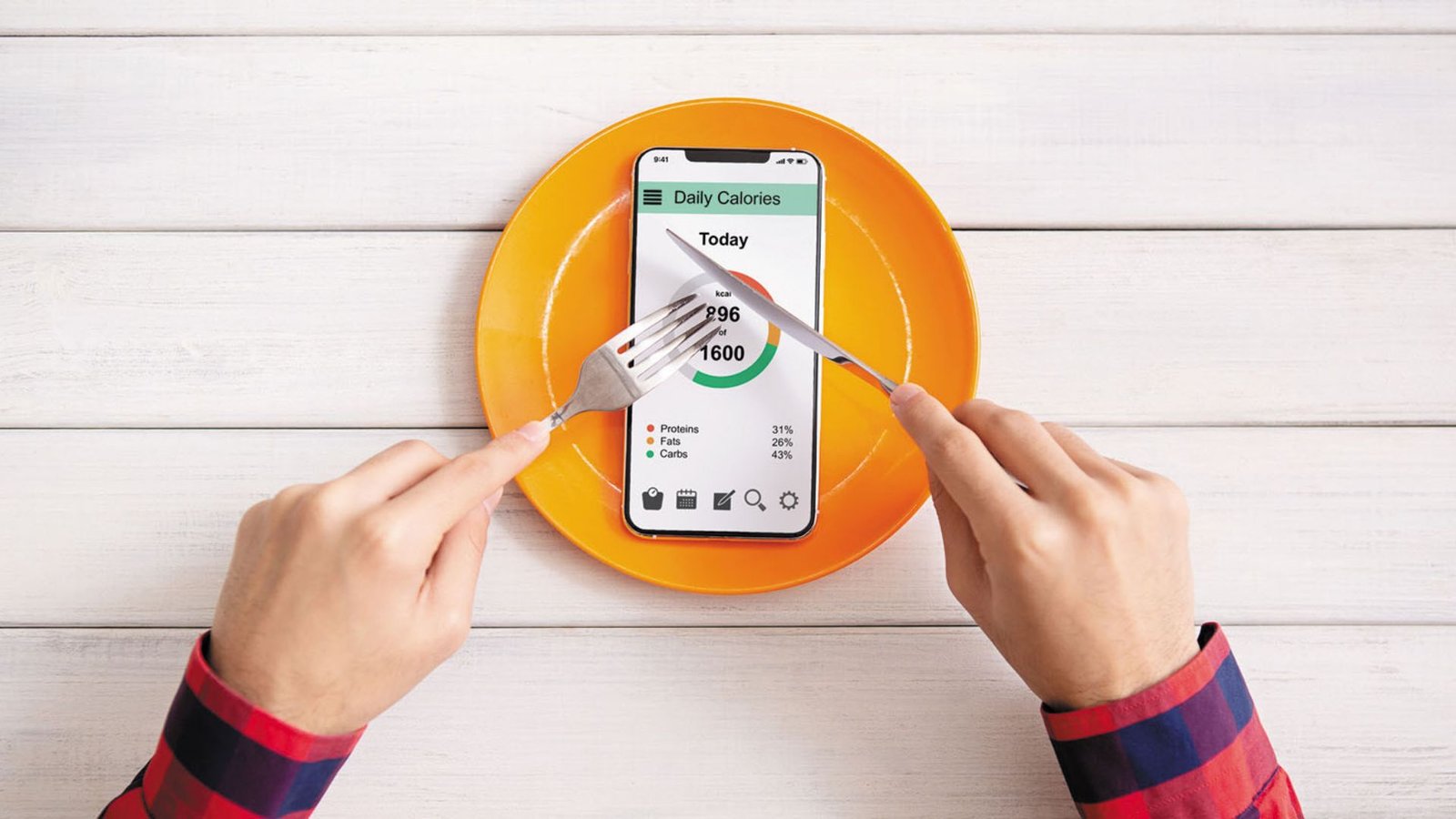 smartphone calorie tracker on a plate with fork and knife illustrating calorie counting.
