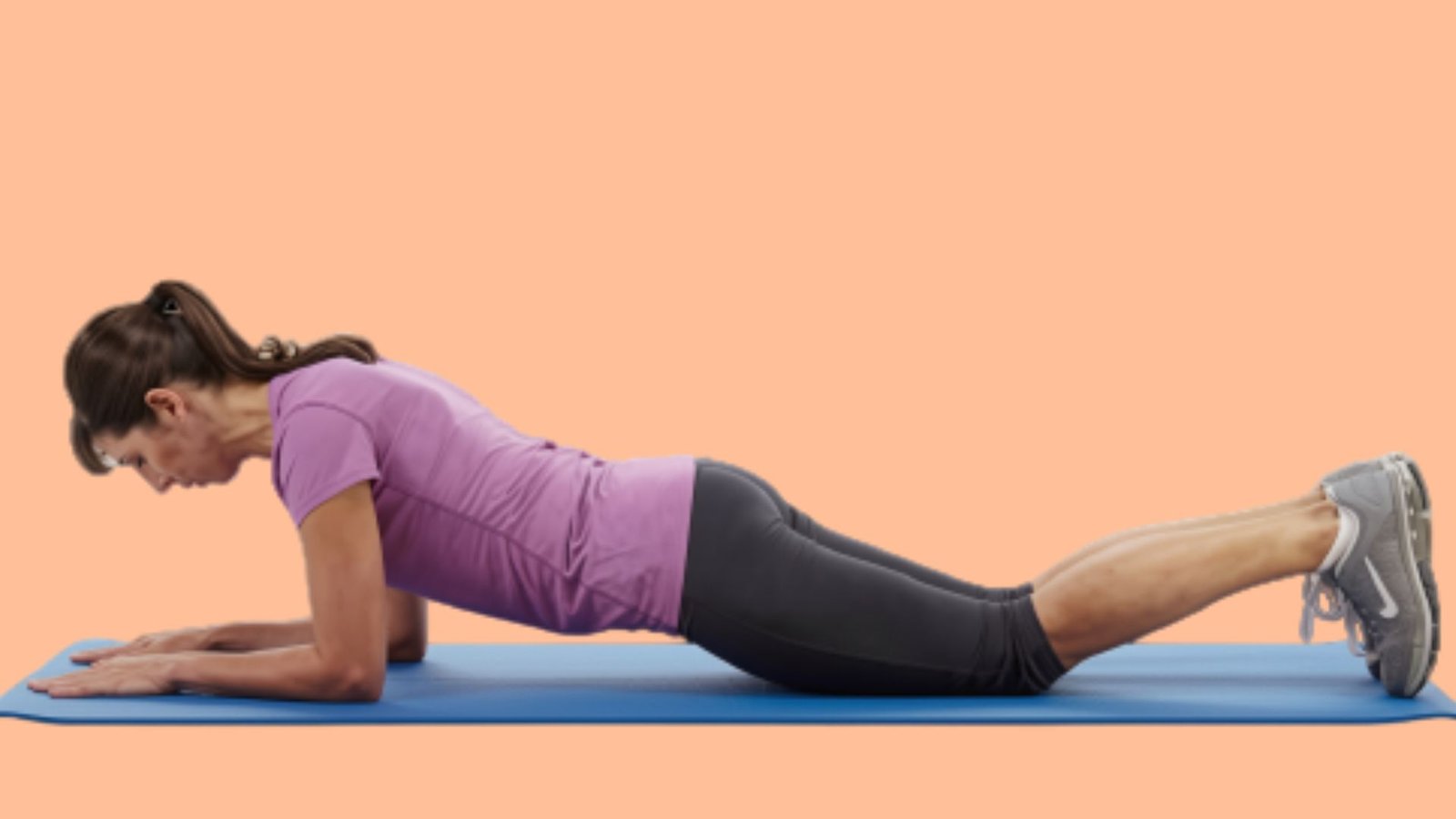 Woman holding a modified forearm plank on her knees to build core strength with reduced joint pressure.