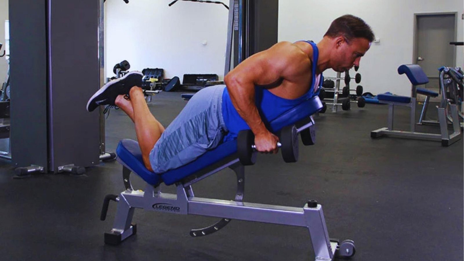 Man doing prone incline dumbbell chest supported row on Legend bench for back muscle.