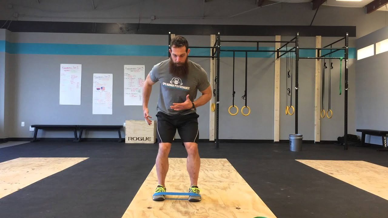 Man performing lateral band walks with a resistance band.