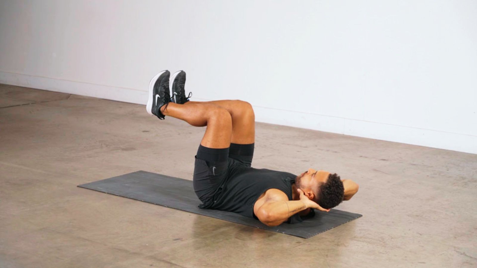 image of a man performing knee pull exercise.