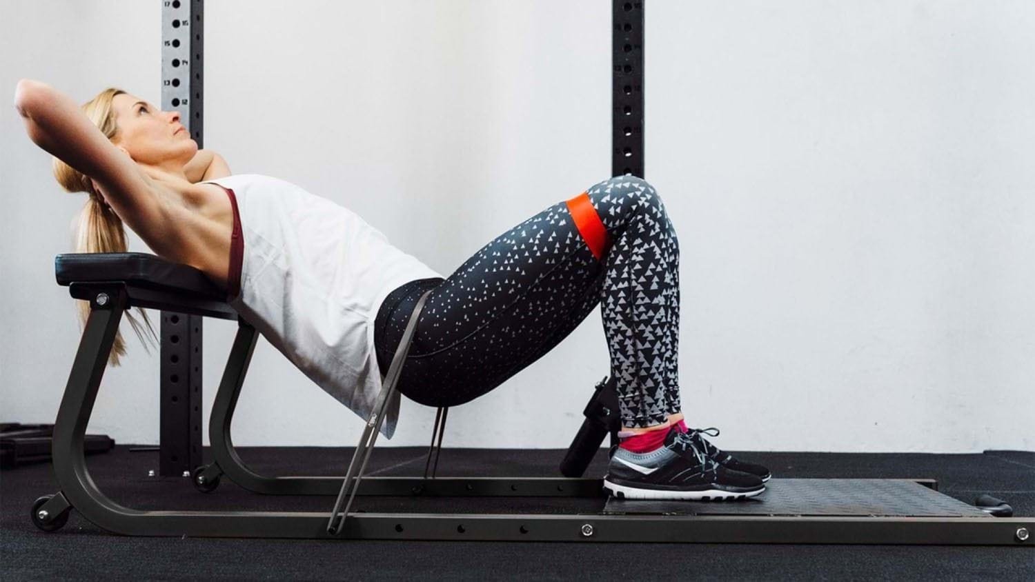 Person performing upper glute exercises using a hip thrust and resistance band.