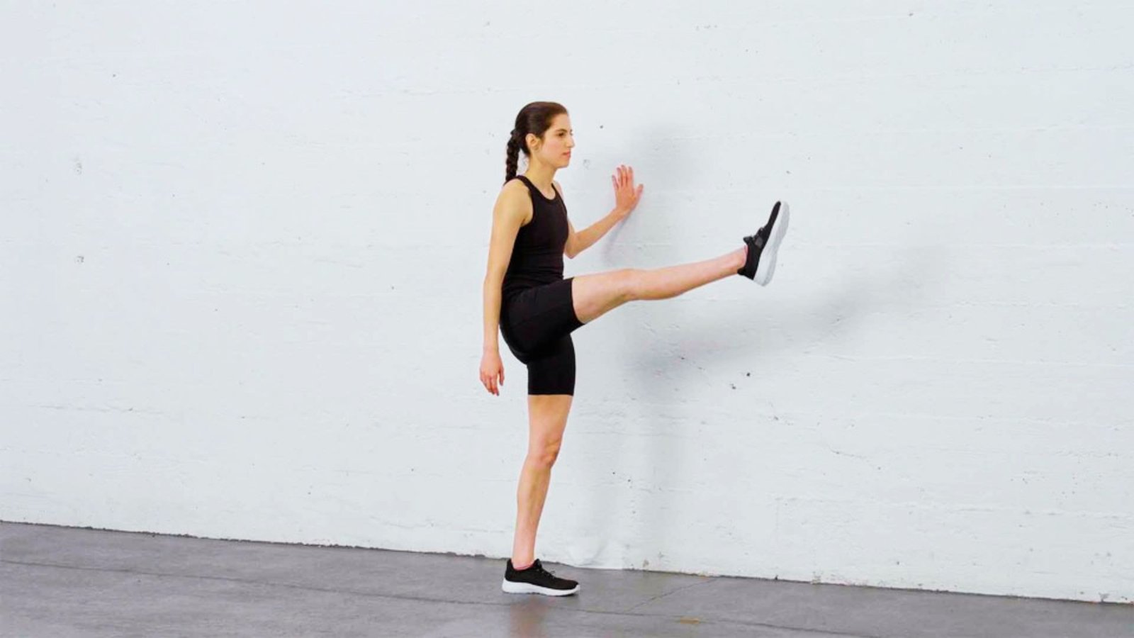 image showing a woman performing leg swing exercise.