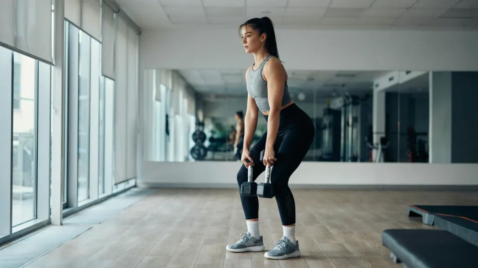 woman demonstrating proper hip hinge form for hip dominant exercises.