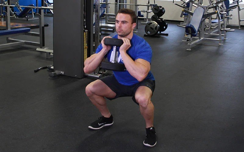 Athlete performing a goblet squat with a dumbbell.