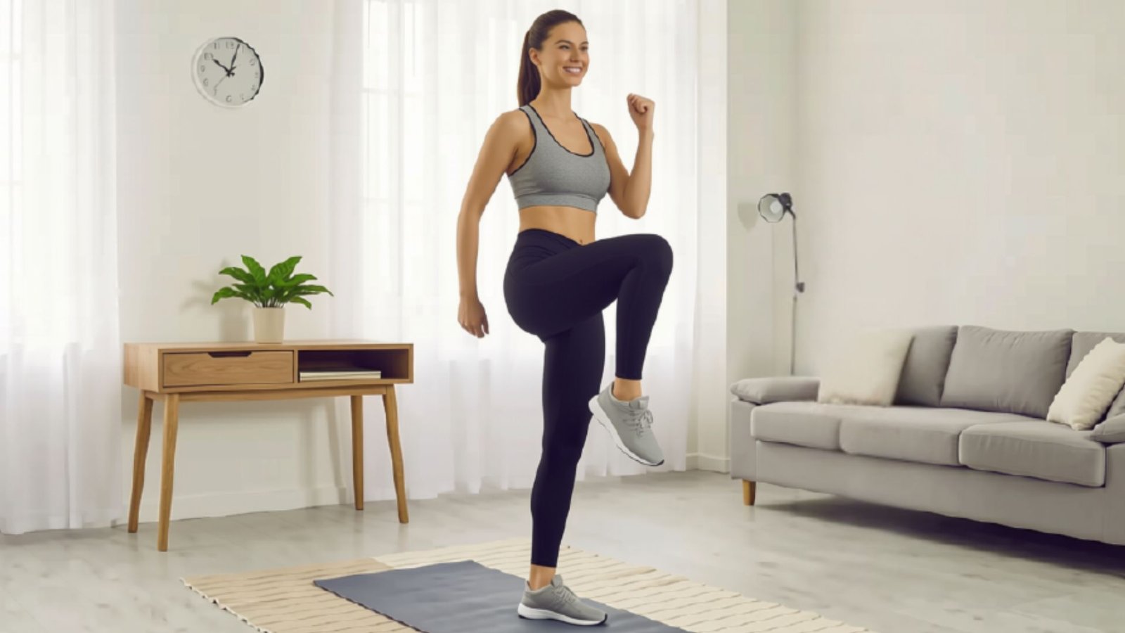 Woman performing standing knee marches at home to engage the core and improve balance and cardiovascular fitness.