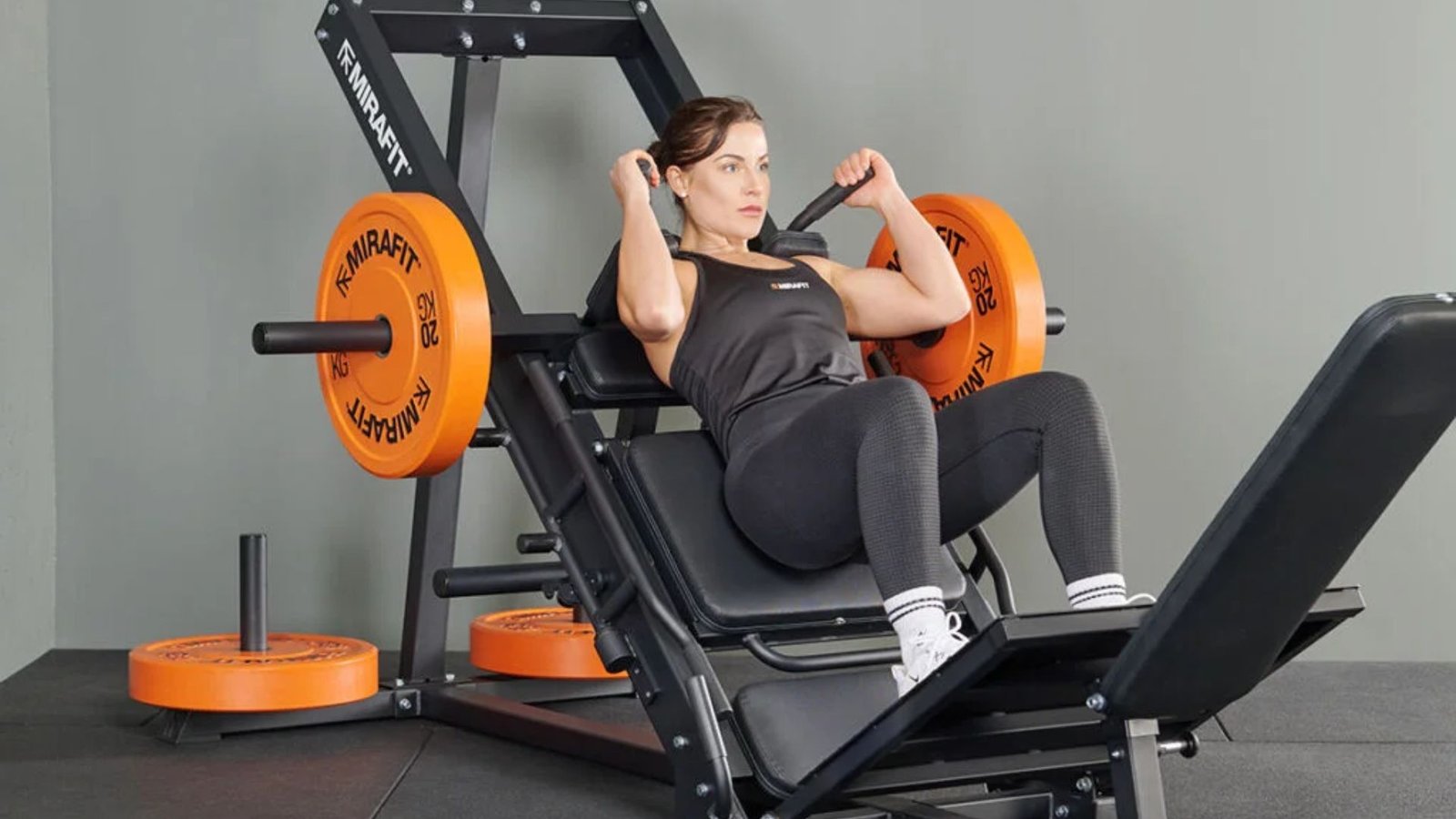 woman using a hack squat machine to build stronger quads with controlled movement.