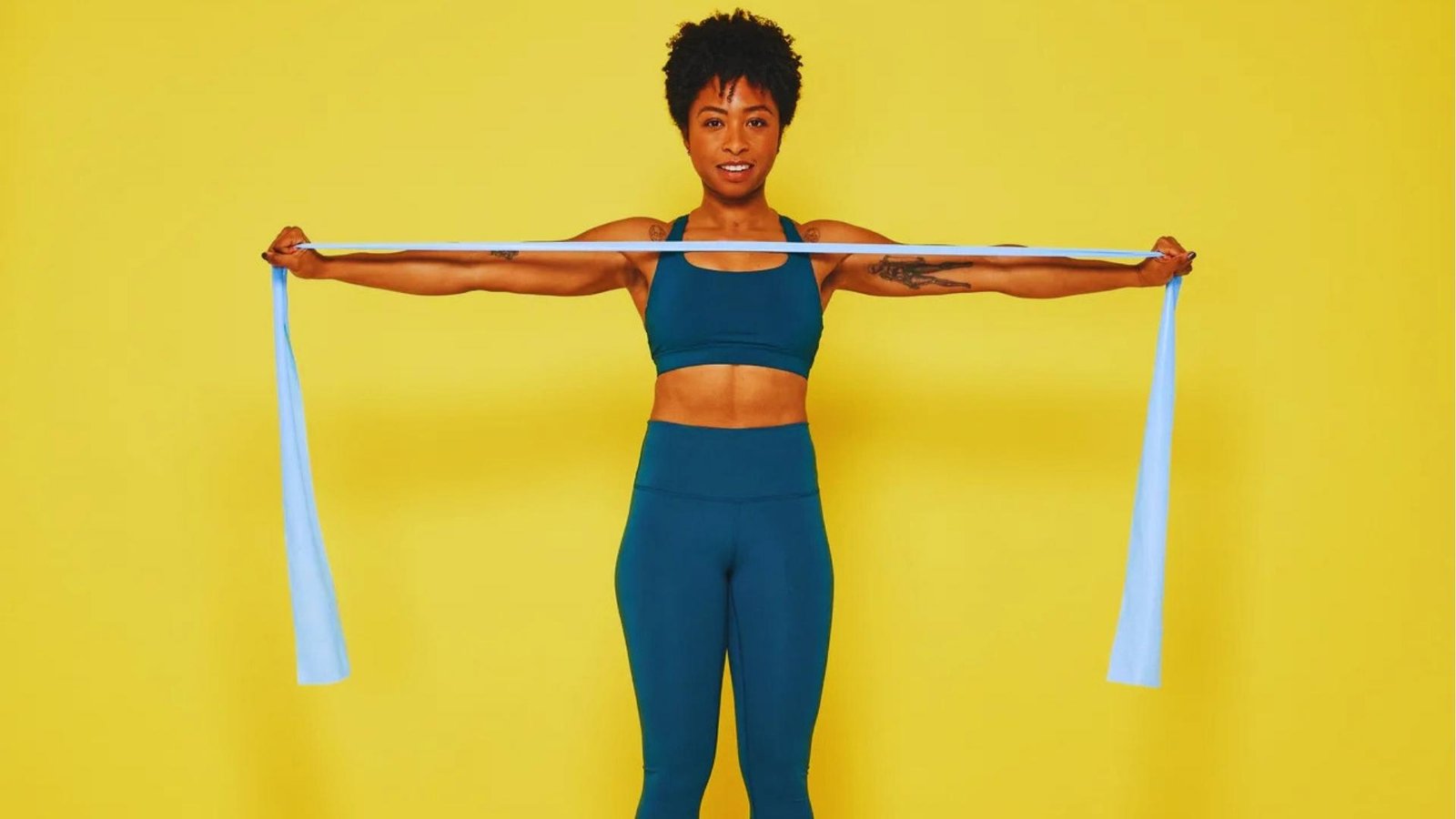Woman doing band pull apart exercise with long blue resistance band for shoulders, full body beginner workout.